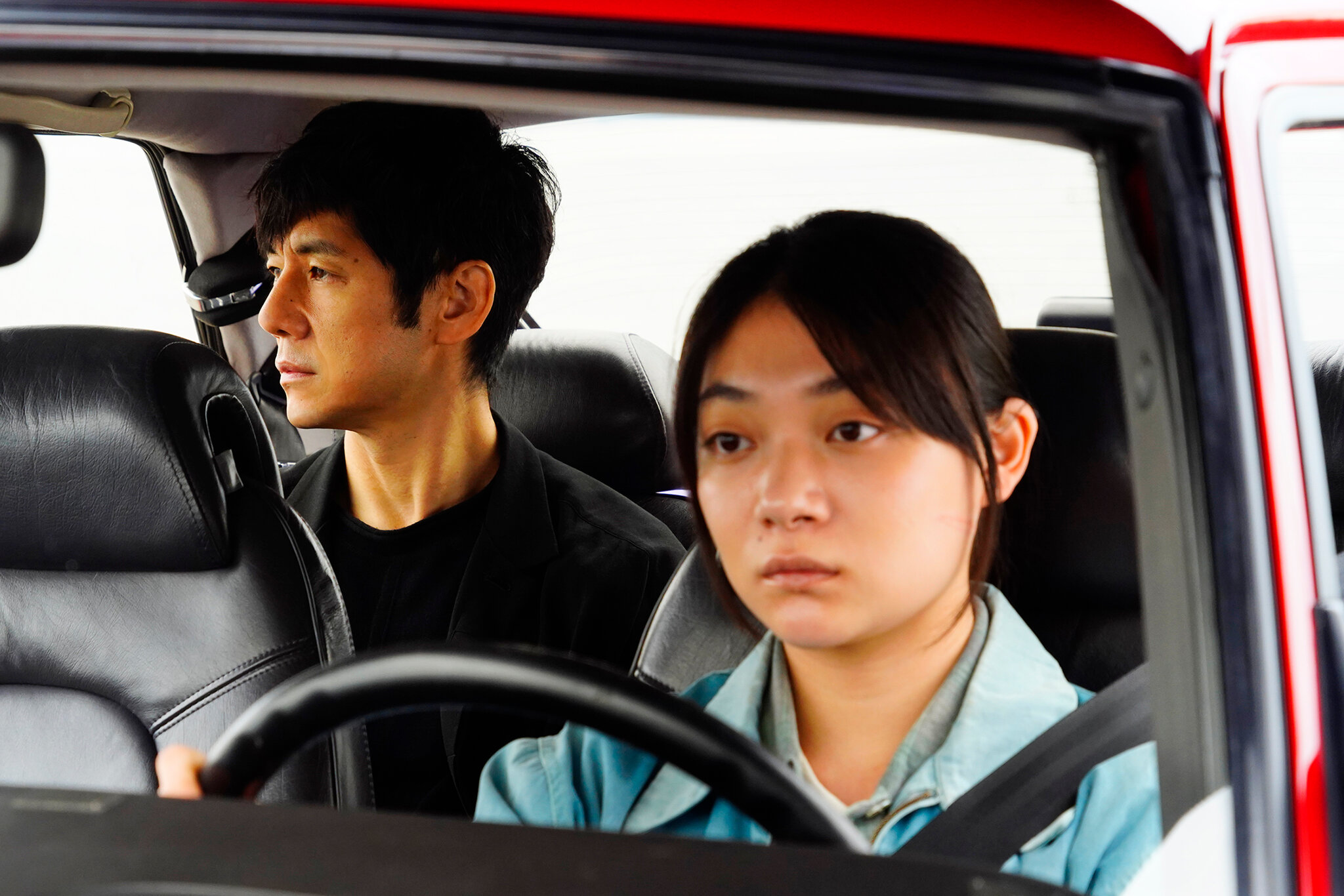 Img:Woman driving car with man in the backseat