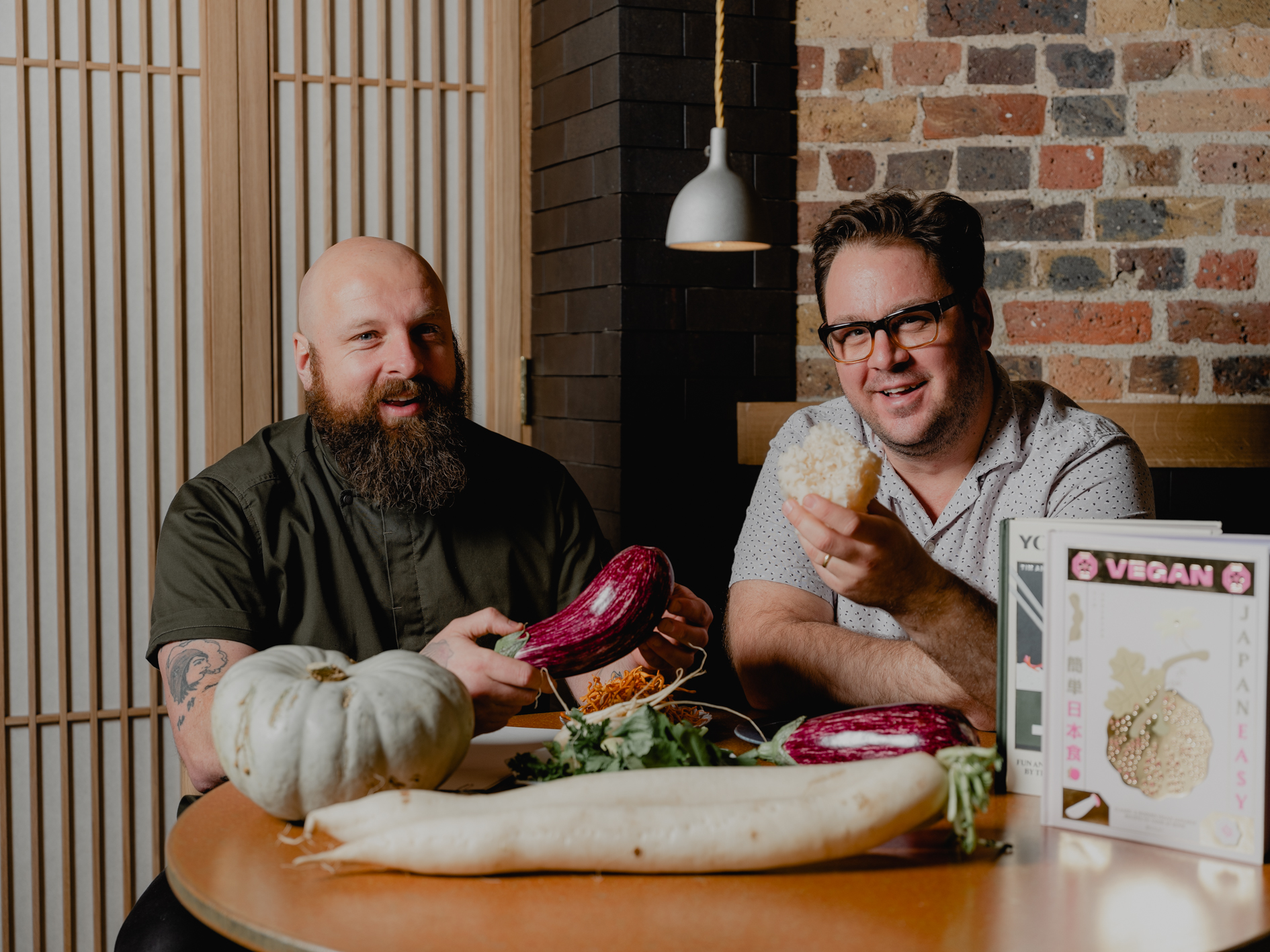 Img:Two men smiling holding vegetables