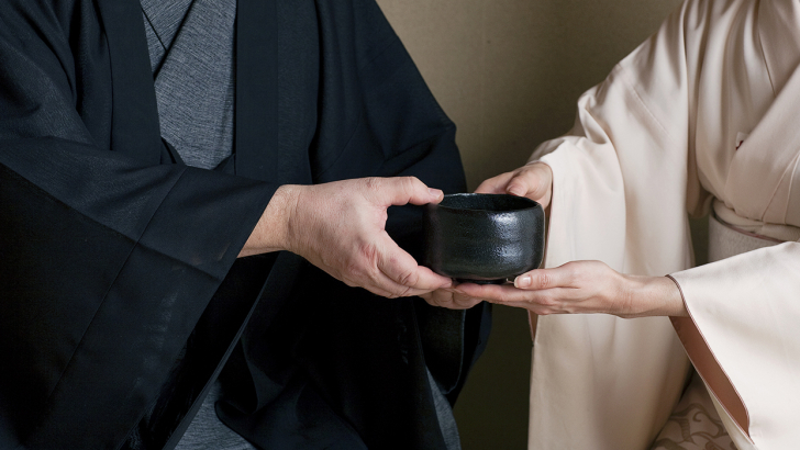 Img:Tea ceremony cup being passed from one person to another