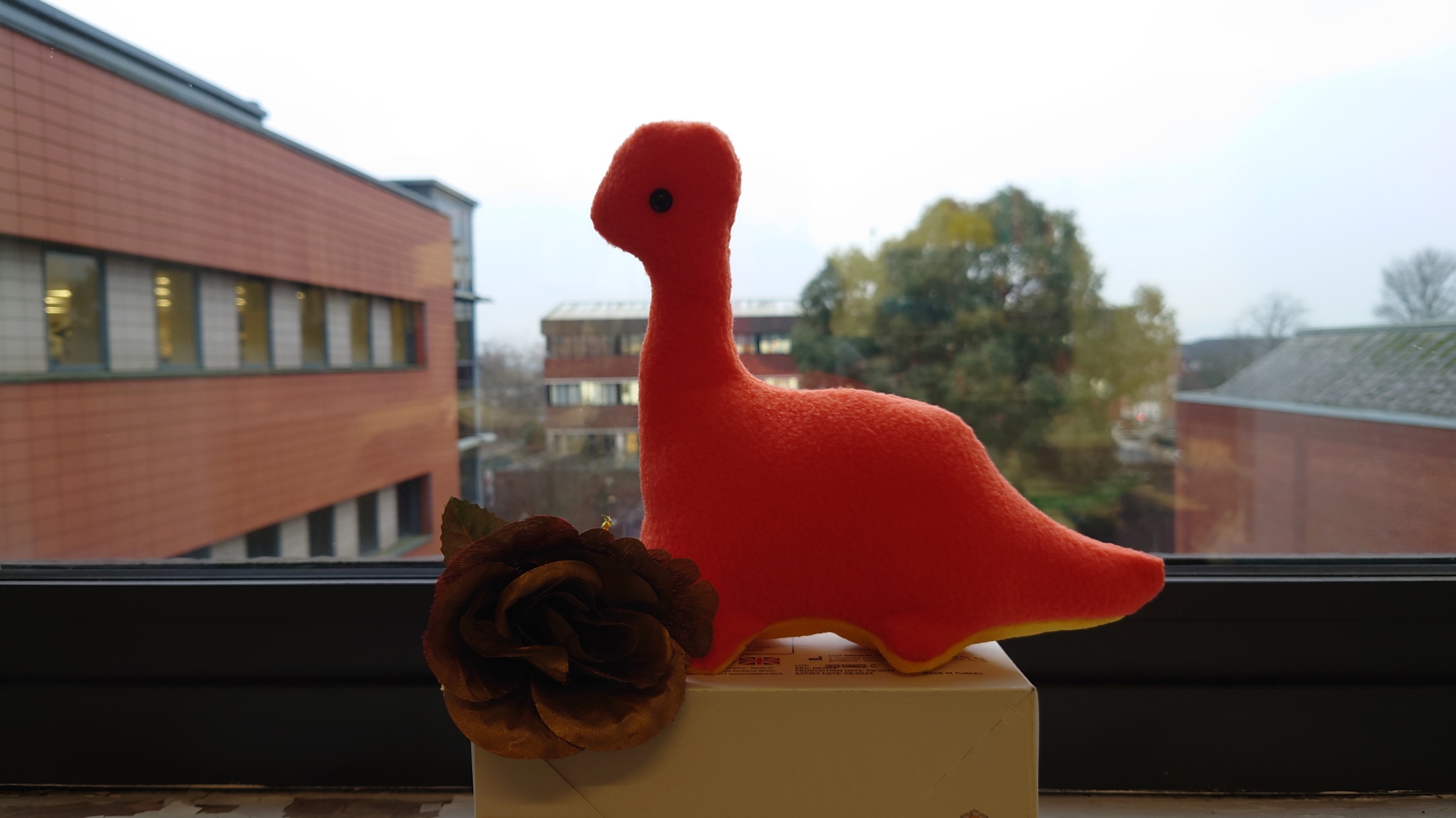 Img:Foam statue of an orange dinosaur with a long neck