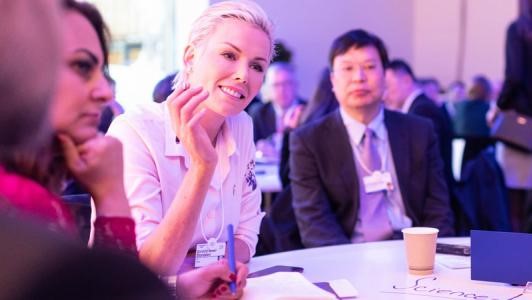 Img:Woman listening at a table during a networking event