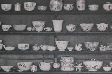 Img:Four tiers of shelves bearing white Japanese ceramics