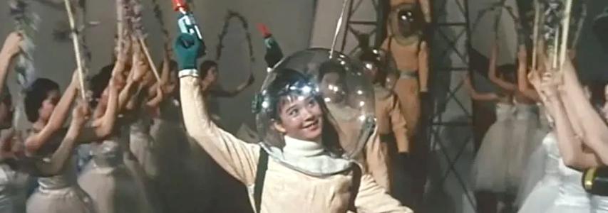 Img:Woman dressed in a spacesuit holding a toy gun