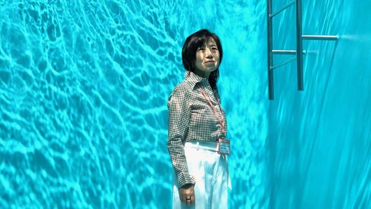 Img:woman staning in the middle of porjected water looks like underwater