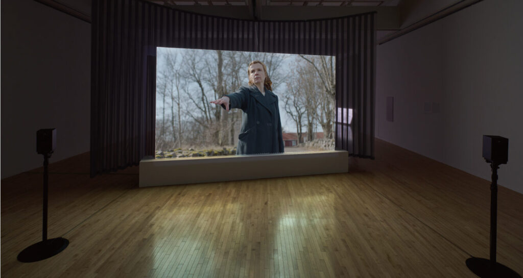 Exhibition room with big screen woman streching her right arm