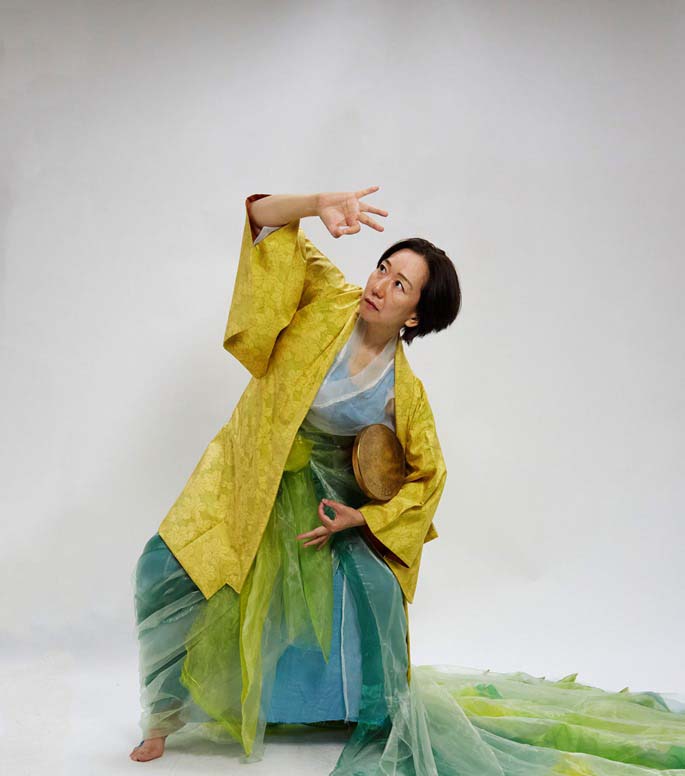 Woman posing dressed in japanese komono with long cloth flowing from her