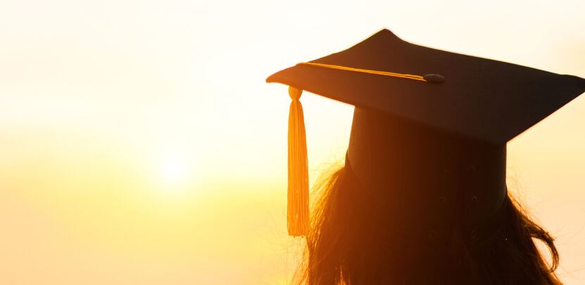 Img:woman wear graduation costume looking at sun