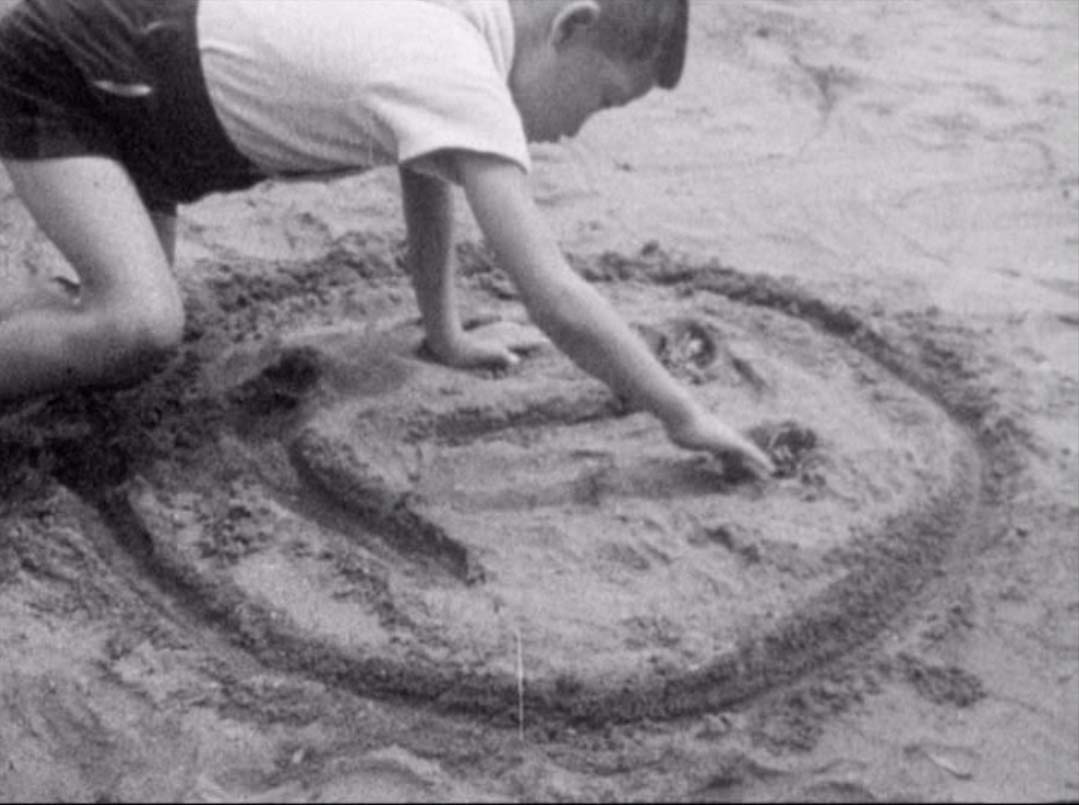 Img:kids writing on sand