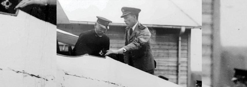 IMG: Man in uniform showing Airplaine to the other uniformed man