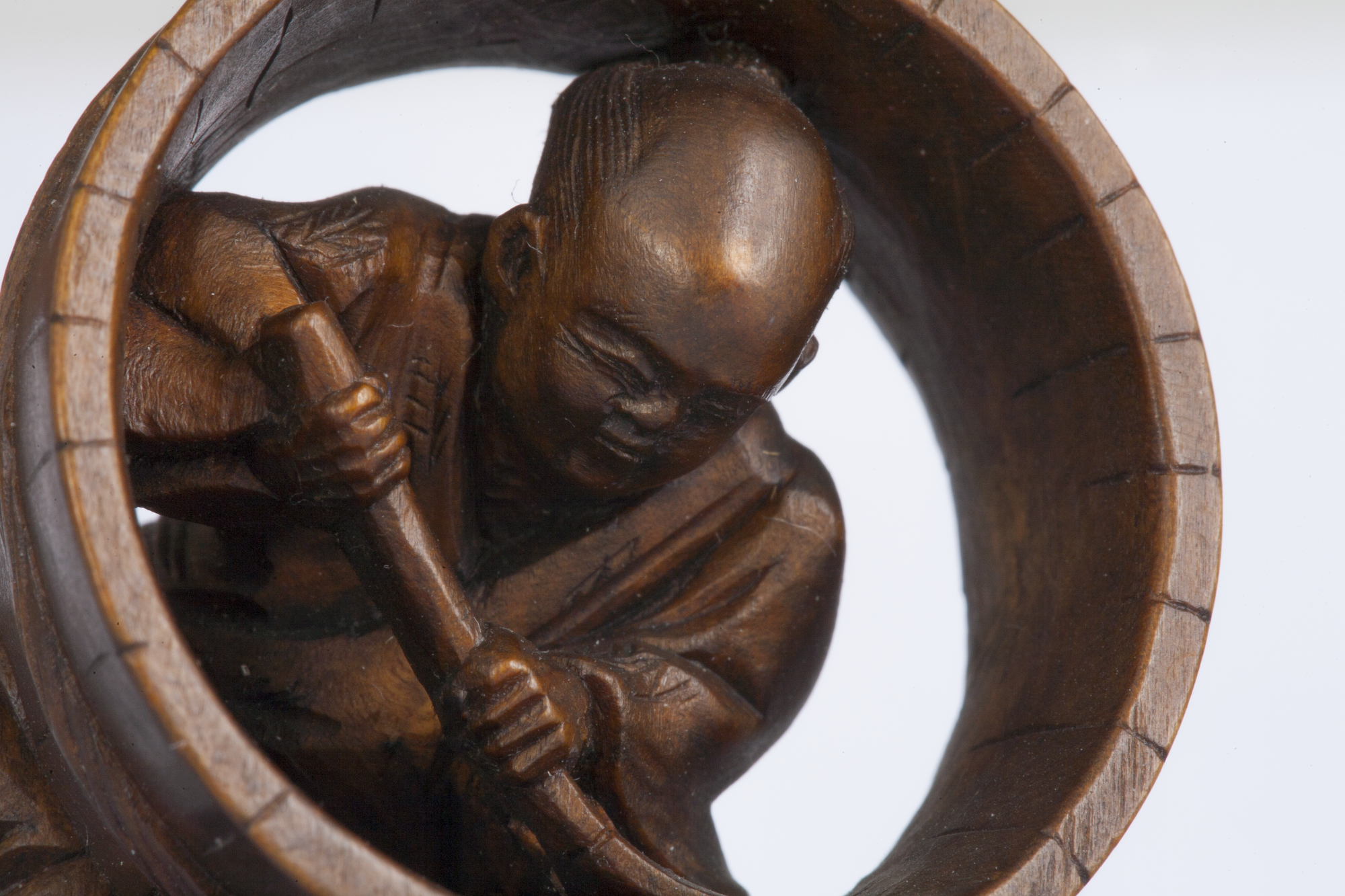 Img: Wooden netsuke charm of an old man holding a broom