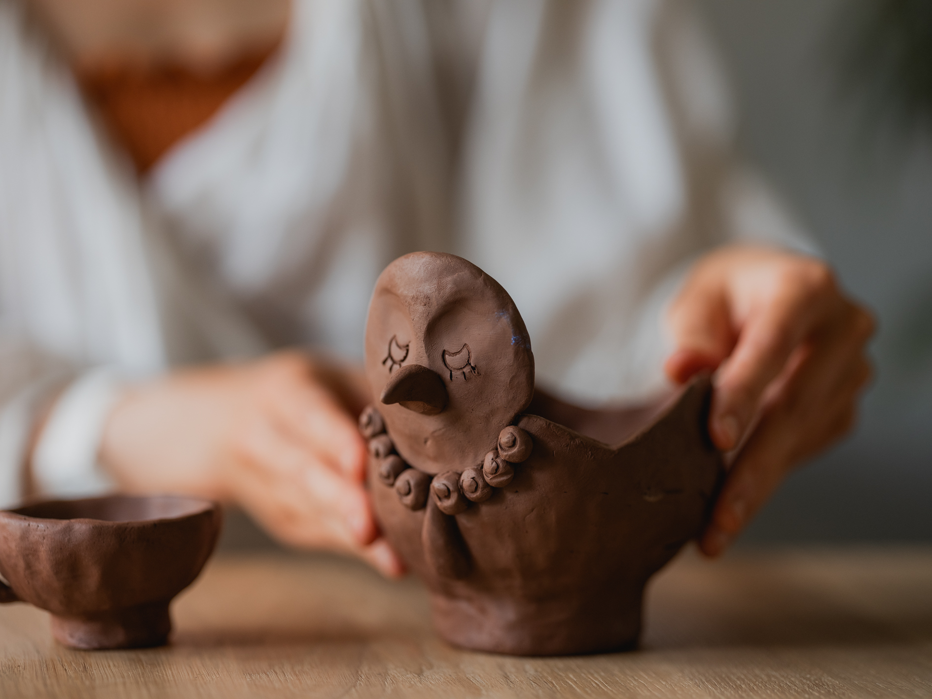 Img:Woman holding ceramic bird