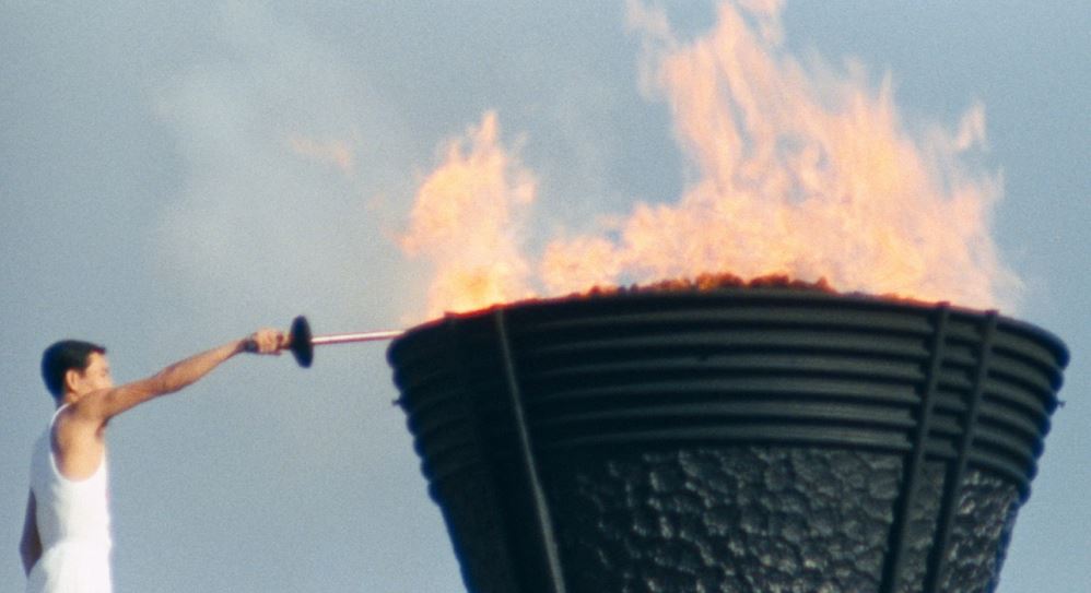 Img: Man lighting the Olympic cauldron at the 1964 Tokyo Olympic Games