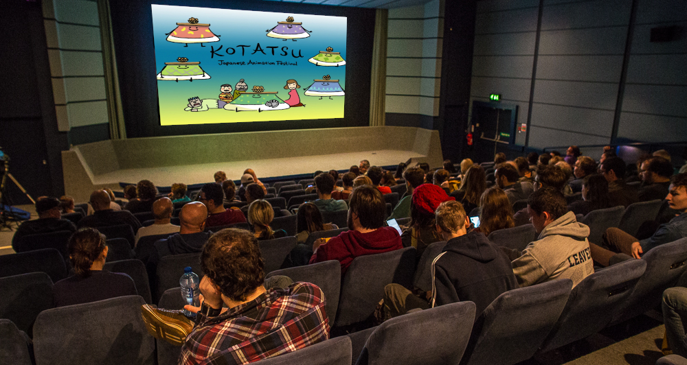 Img: Cinema audience looking at a screen bearing the words 'Kotatsu Festival' and some cartoon characters