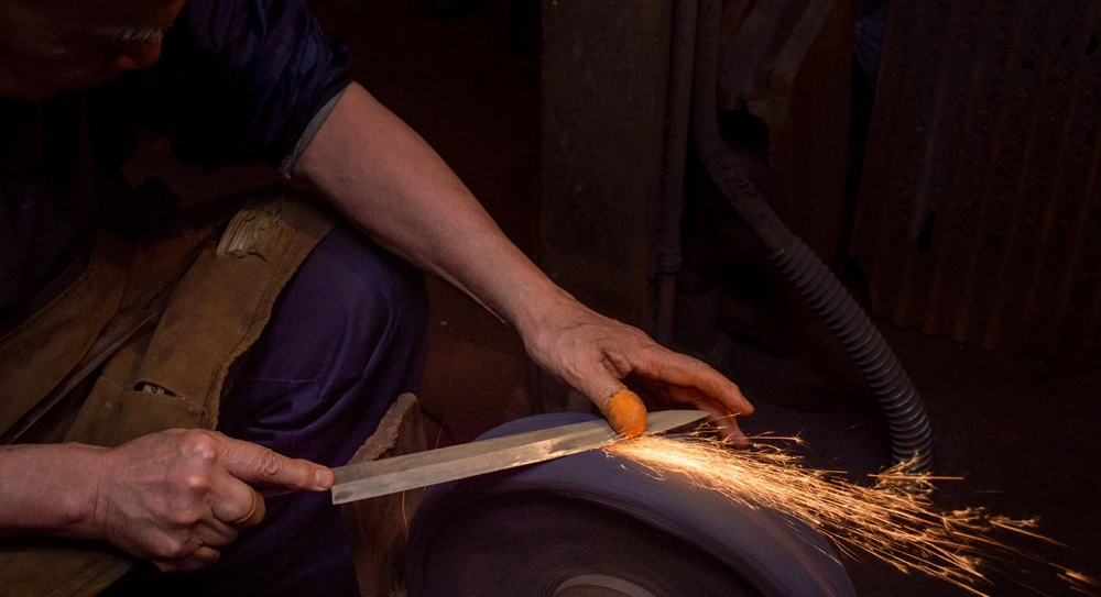 Img:A man forging a knife