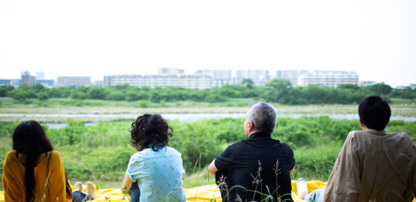 Four people sitting looking out at a landscape
