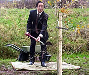 Minister Kishino helps to plant the tree 