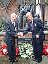 Ambassador Orita and former POW Les Dennison shake hands in front of the sculpture entitled 'Reconciliation'